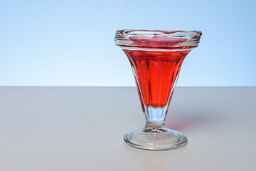 Copa con jugo color rojo con iluminación frontal