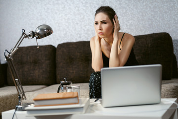 Woman shocked by pandemic news. Girl is watching news on a laptop. Coronavirus. Quarantine. isolation, social distancing, freelance work from home office, self-isolation.