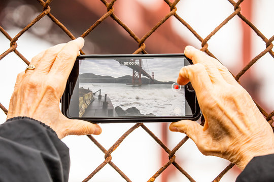Close up of a cell phone using the camera to take a picture of the Golden Gate Bridge.