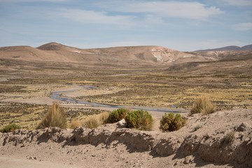 High Andean altiplano desert landscape with river down in the valley