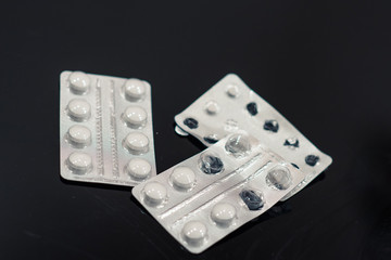 Electronic thermometer with tablets and capsules on a white background - protection against influenza during quarantine, coronavirus, lettering covid19