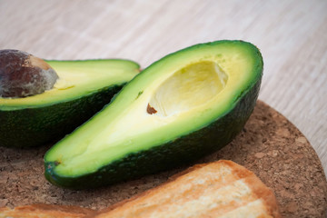 Halved avocado on a stand with croutons. Food photography.