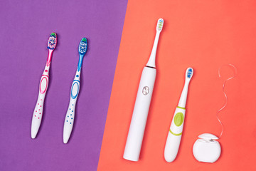 Manual and electric toothbrushes on pink coral background. Dental care