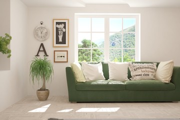 White living room with sofa and summer landscape in window. Scandinavian interior design. 3D illustration
