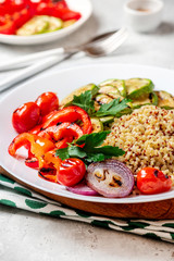 Bulgur, quinoa and grilled vegetables in a plate on the table. Tasty and healthy vegetarian food.