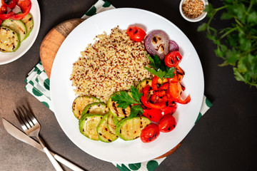 Bulgur, quinoa and grilled vegetables in a plate on the table. Tasty and healthy vegetarian food.