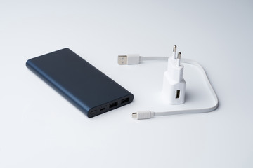 White USB power adapter, cable and blue power bank for divice isolated on a white background.