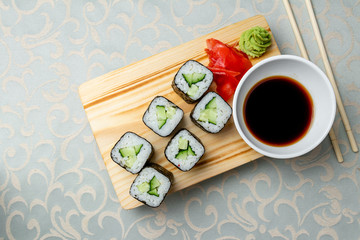 Fototapeta na wymiar roll with cucumber on board with soy sause top view