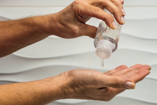 Hands putting on hydroalcoholic gel to prevent the spread of virus
