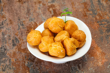 Sweet tasty profiteroles heap in the bowl