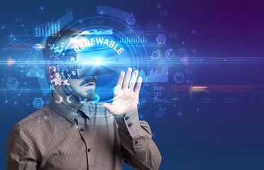 Businessman looking through Virtual Reality glasses with RENEWABLE inscription, innovative technology concept