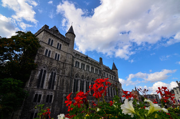 Fototapeta na wymiar Ghent,Belgium,August 2019.Geraard de Duivelstraat Castle.The main facade overlooks the water: it is an example of the medieval buildings of the city.Blue sky with white clouds.Planters along the canal