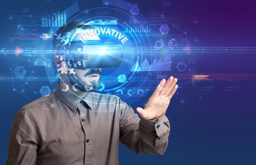 Fototapeta premium Businessman looking through Virtual Reality glasses with INNOVATIVE inscription, innovative technology concept