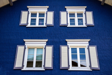 Contrast wooden windows with blinds. No people. Front view. Old fashioned style.