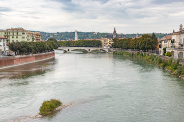 Fototapeta premium View from the Castelvecchio Bridge - Ponte di Castelvecchio of the Adige river, embankments and Verona city in Italy