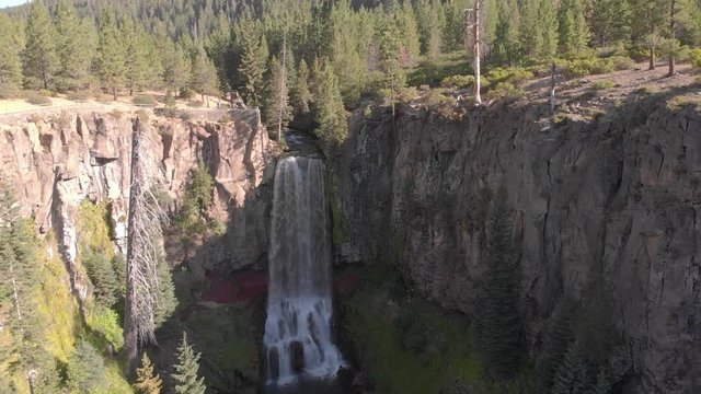 Tumalo Falls near Bend, Oregon. Waterfall cascades over rocky cliff in evergreen pine forest. 