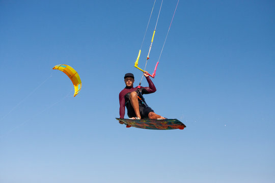 Kiteboarder or kite surfer. Man performing kitesurfing kiteboarding tricks.