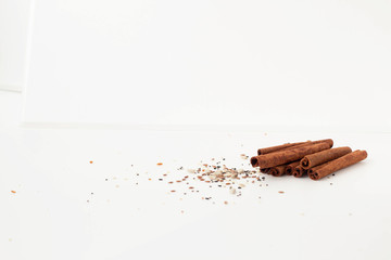 Close-up of cinnamon sticks and seeds on a white back