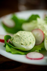 boiled stuffed eggs with green cheese filling with arugula leaves and radish