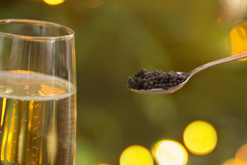 black caviar in  spoon and  glass of champagne
