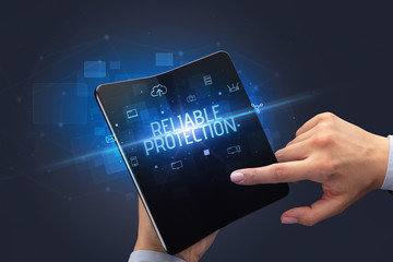 Businessman holding a foldable smartphone with RELIABLE PROTECTION inscription, cyber security concept
