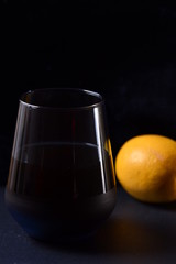 a glass of juice next to a lemon