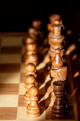 Close up image of chess board and chess pieces with lopsided sunlight and shadows