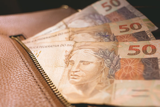 Real Currency, Money from Brazil. 50 Reais banknotes in a female bag.