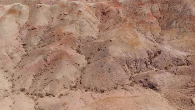 Aerial tilt on the colorful rock formations of Tsagaan Suvarga mine, Gobi Desert, Mongolia