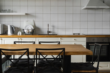 Modern, bright, clean, kitchen interior with stainless steel appliances in a luxury house. Kitchen in luxury mansion. Modern architecture contemporary, interior. Stylish kitchens interior with table.