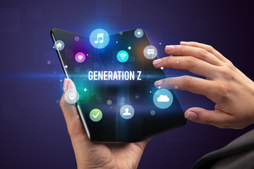 Businessman holding a foldable smartphone with GENERATION Z inscription, social media concept