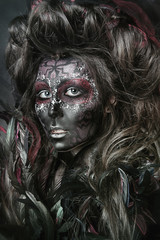 close up portrait of terribly beautiful girl with Halloween skull makeup. Black face painting. lush hair