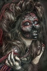 close up portrait of terribly beautiful girl with Halloween skull makeup. Black face painting. lush hair