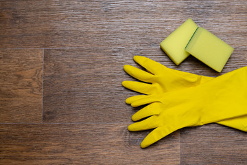 yellow rubber gloves and washcloths on wooden background