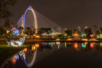Obraz premium Nightscape of new landmark Konan Ai-Qin Bridge in Taichung City, Taichung Central Park at the Xitun District Shuinan Economic and Trade Area. The second largest park in Taiwan