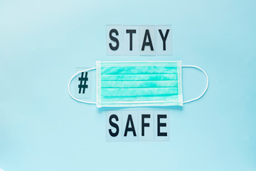 COVID-19 SARS-COV-2 Pandemic  personal protective equipment for the respiratory tract-mask. Text STAY SAFE.  Blue background. Copy space.