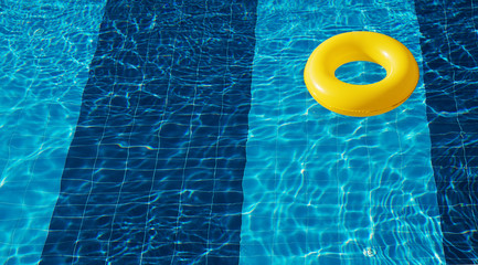 Yellow pool float, ring floating in a refreshing blue swimming pool