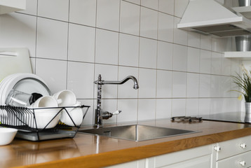Kitchen sink and faucet. Stainless kitchen sink and tap water. The interior of the modern kitchen room in the loft apartment. Built-In Appliances.