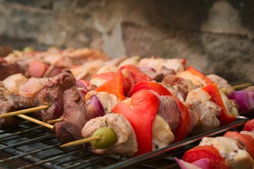 Pieces of meat and vegetable skewers on the grill at a typical argentinian barbecue.