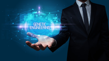 Man hand holding GENETIC ENGINEERING inscription, technology concept