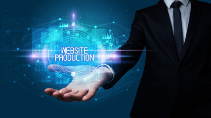 Naklejka premium Man hand holding WEBSITE PRODUCTION inscription, technology concept