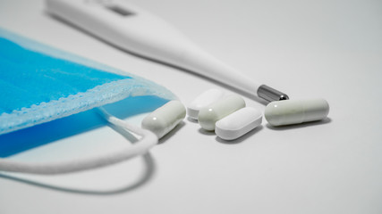 Medical face masks , pills and thermometer on white background. covid-19, healthcare concept