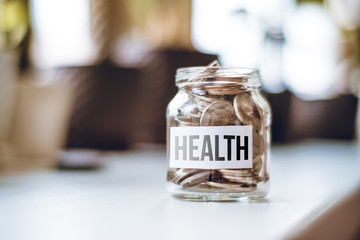 Fototapeta na wymiar Health money accumulation concept - glass jar with coins.