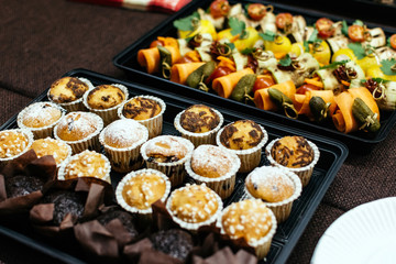 Cupcakes in plastic plates on a brown table