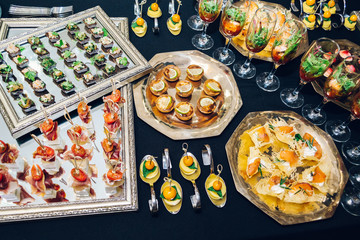 Different desserts in plates on a black table