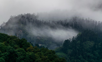 a beautiful mountain view with fog and clouds