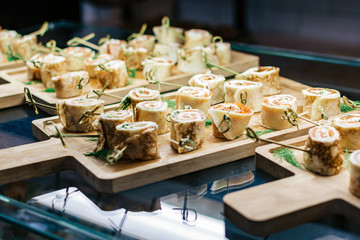 Meat rolls on a cutting board on a glass table