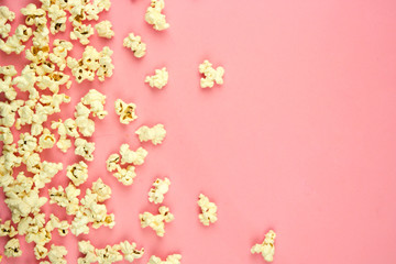popcorn sprinkled on a pink background, place for text, concept of relaxing and spending free time, watching movies