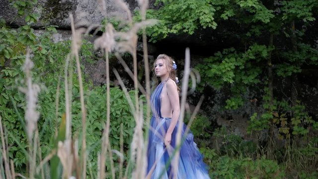 Portrait of young girl in a blue fairy dress in the spring forest. Image of a fairy tale character from elven tales