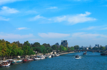View of the Seine with ferries and a bridge in Paris in summer. France